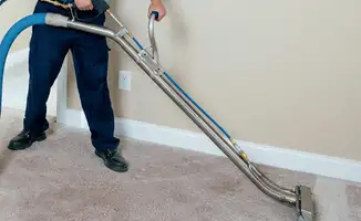 Professional operating a liquid removal machine on a carpeted floor in Dallas, TX